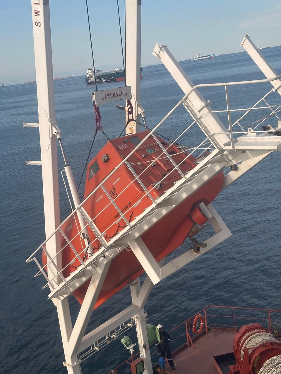 An orange free-fall lifeboat on its launching ramp