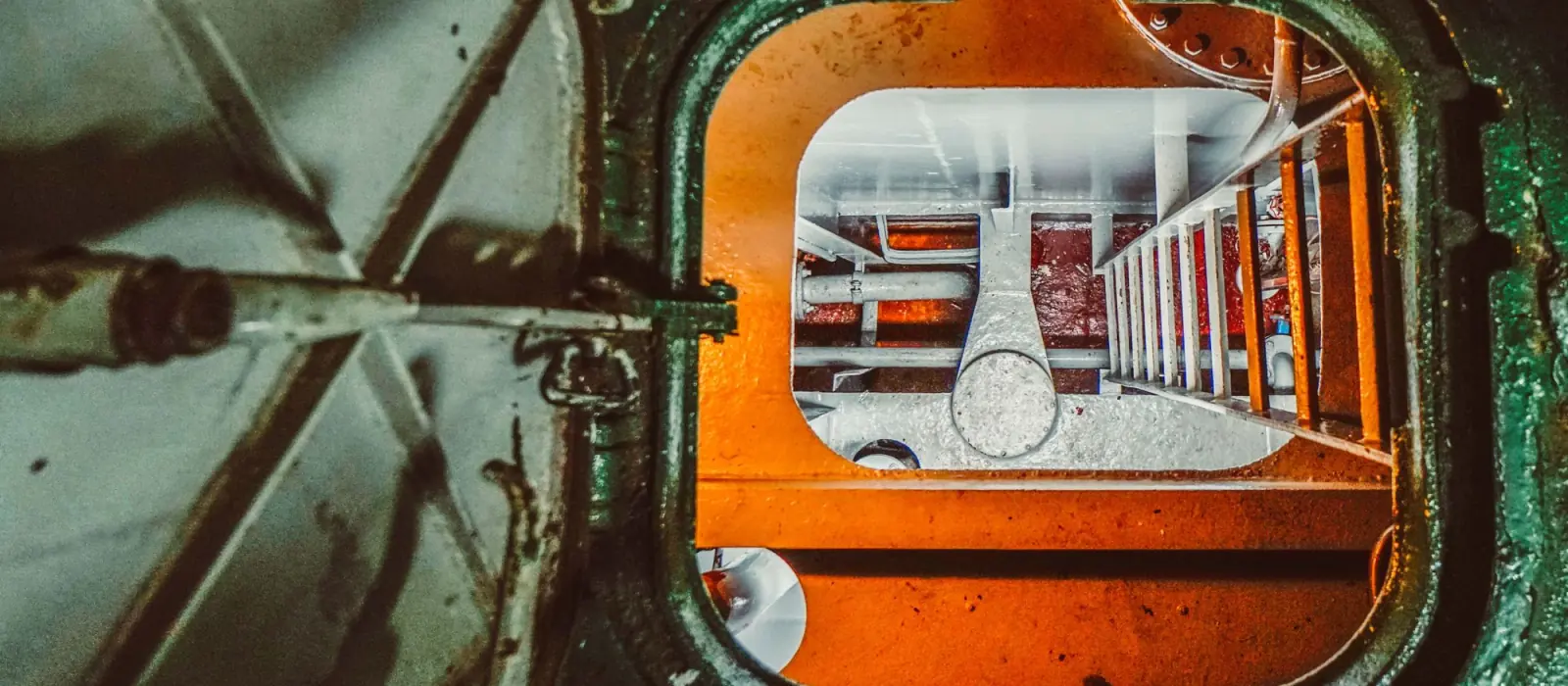 Looking down through an open manhole into an enclosed space